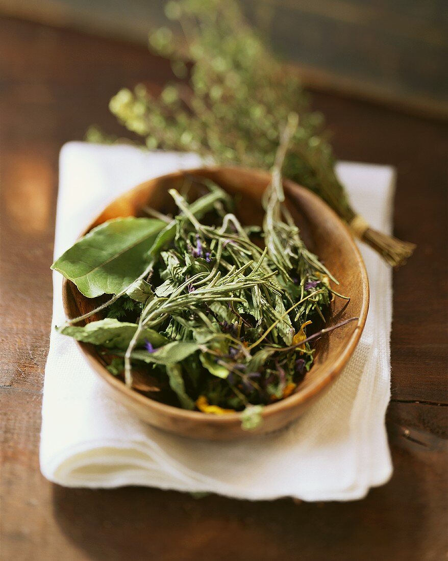 Several Dried Herbs in a Wooden Bowl