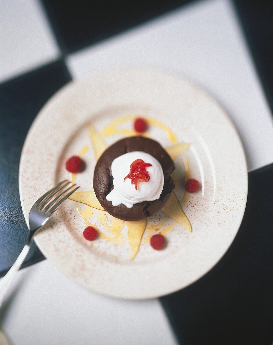 Schokoladentörtchen mit Sahneklecks und Himbeeren