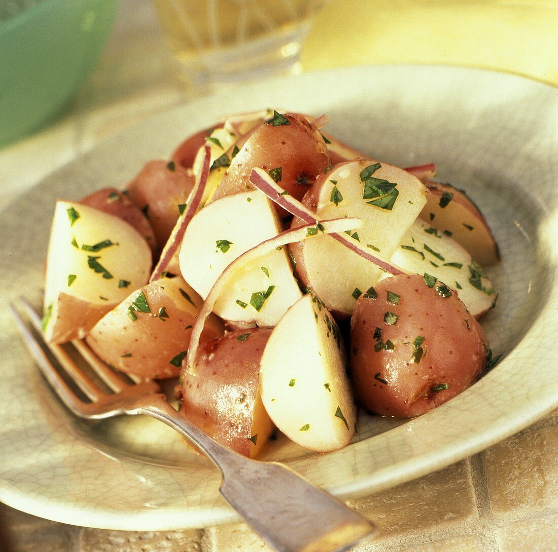 Gekochte rote Kartoffeln mit Petersilie und Zwiebeln