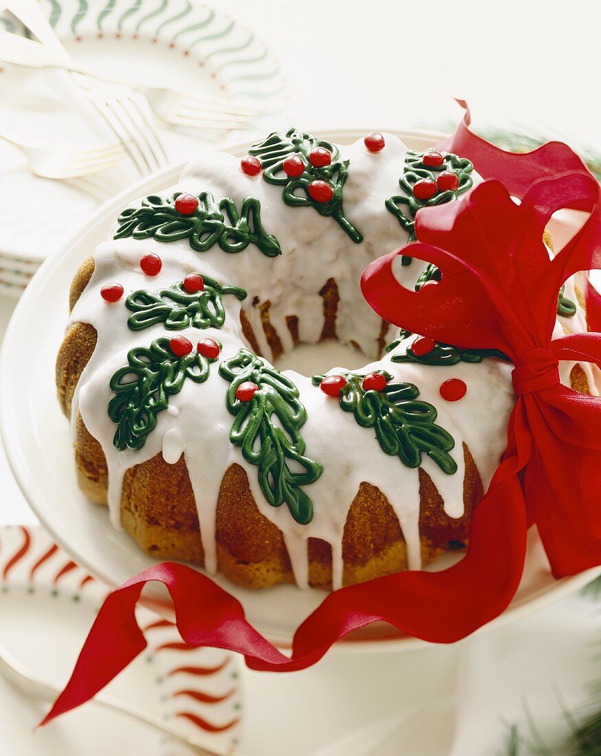 Christmas Bundt Cake with Icing and Holly Decorations; Ribbon