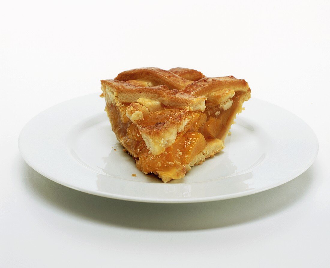 Piece of peach pie on white plate