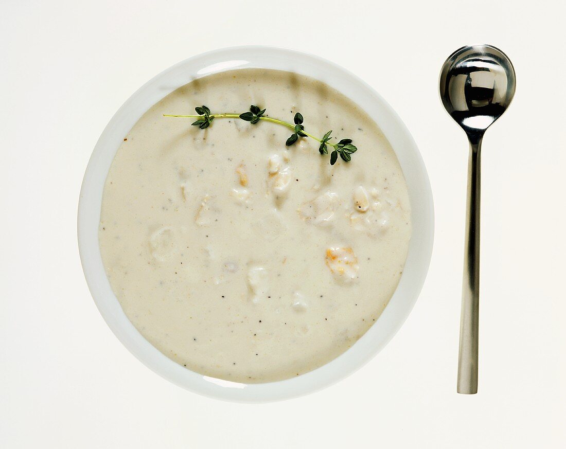 Clam chowder (USA) with thyme, spoon beside it