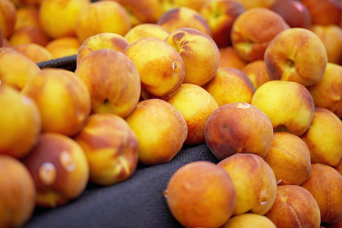 Many fresh peaches on a market stall