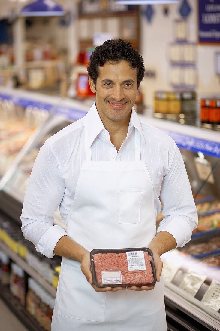 Butcher showing pack of mince in a supermarket