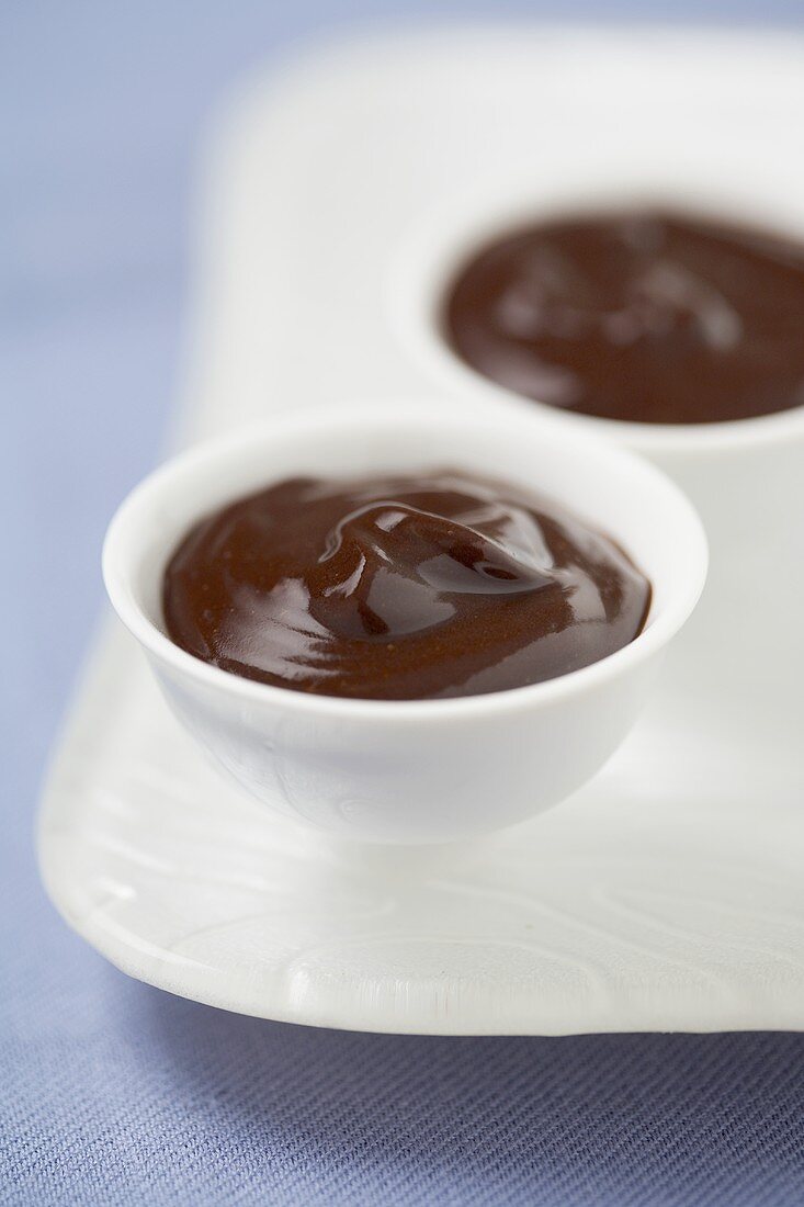 Schokoladenpudding in zwei Schälchen auf Tablett