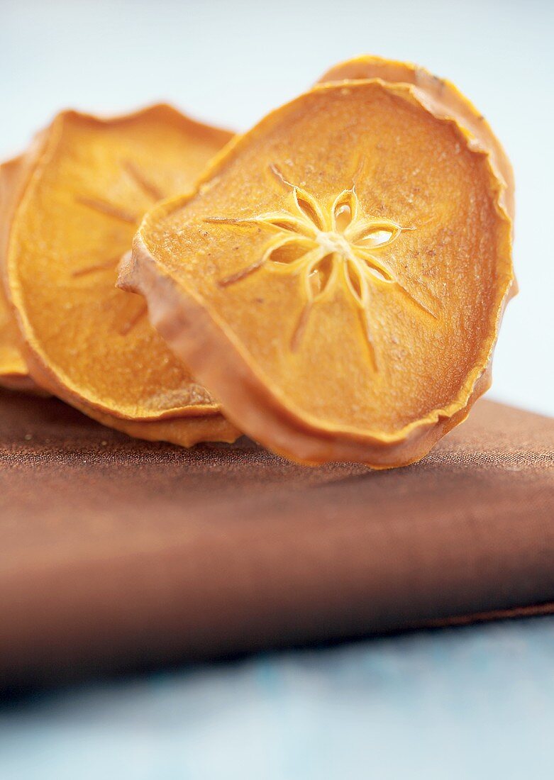 Dried Sharon fruit slices on chopping board