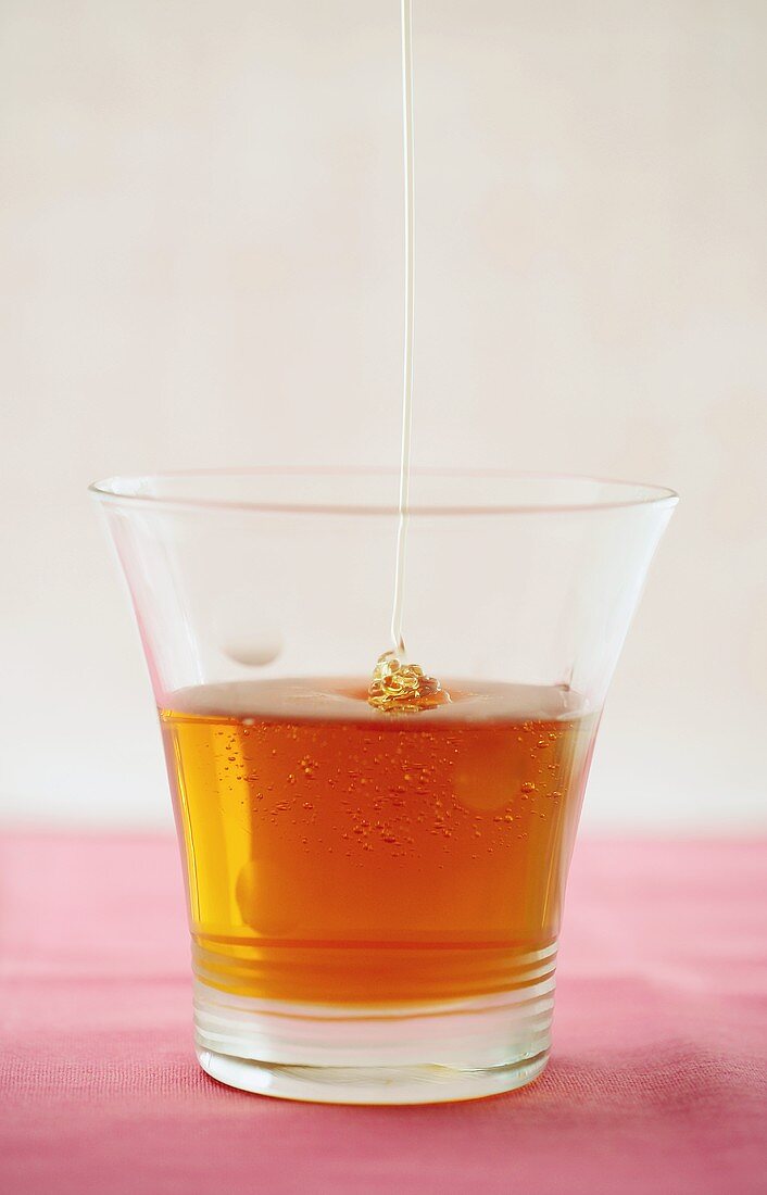 Honey trickling into a glass