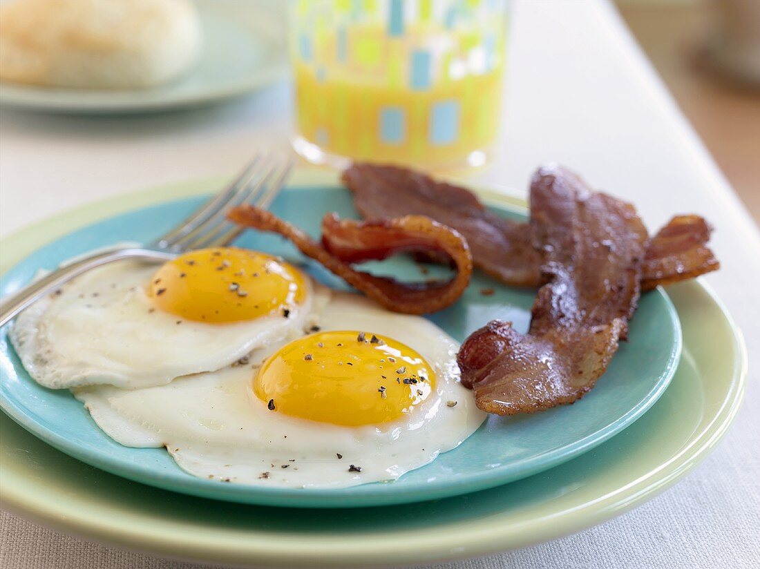 Spiegeleier, Speck und Orangensaft zum Frühstück