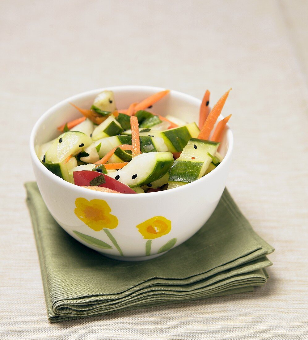 Cucumber salad with carrots in bowl on green napkin