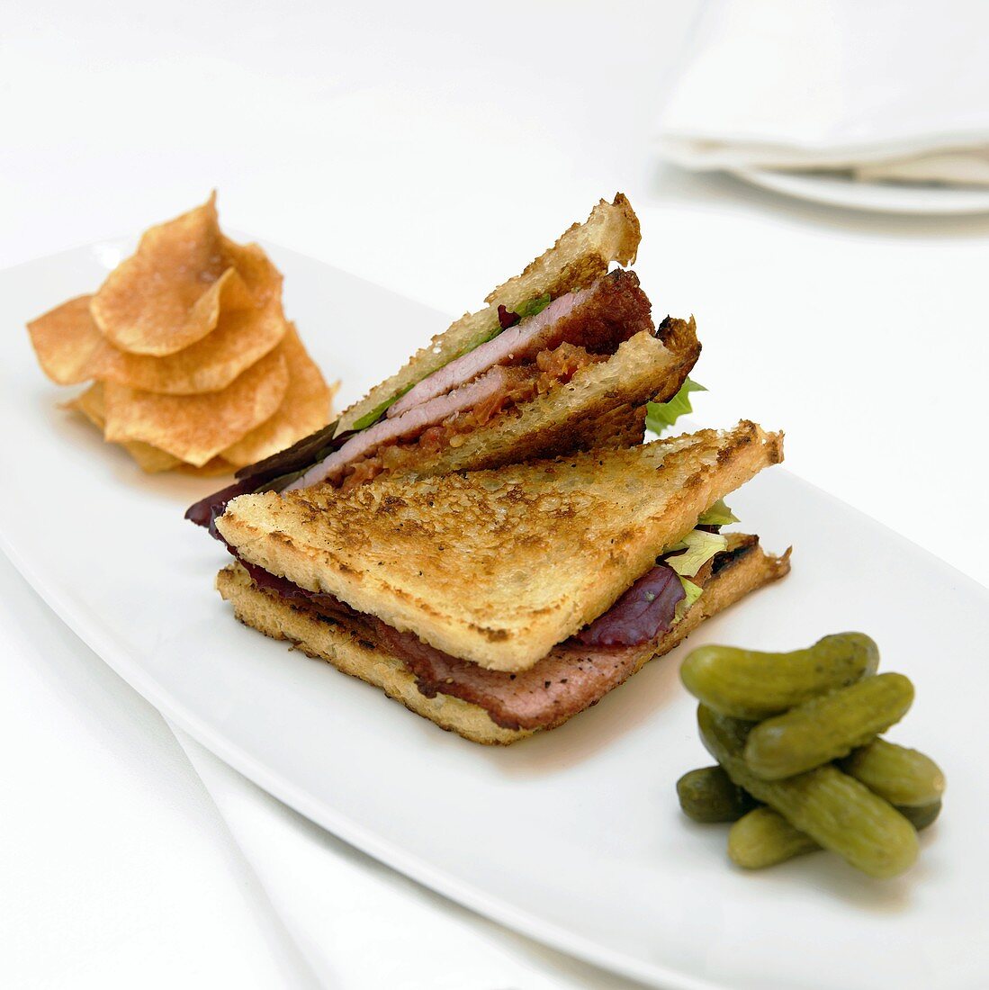 Grilled Ham Sandwich, BLT, On a Plate with Pickles and Chips