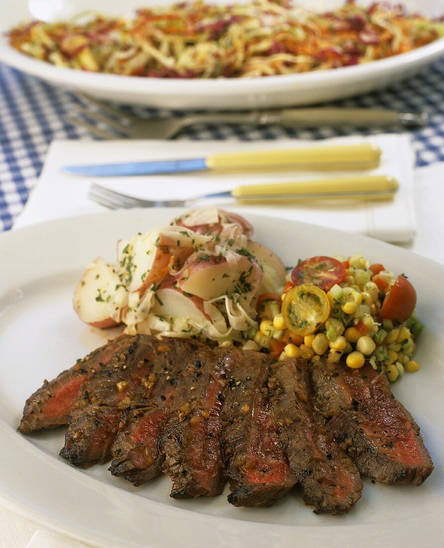 Sliced beef steak with potatoes and sweetcorn salad
