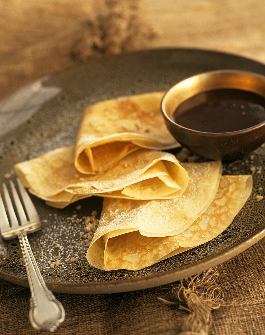 Crepes with icing sugar and chocolate sauce