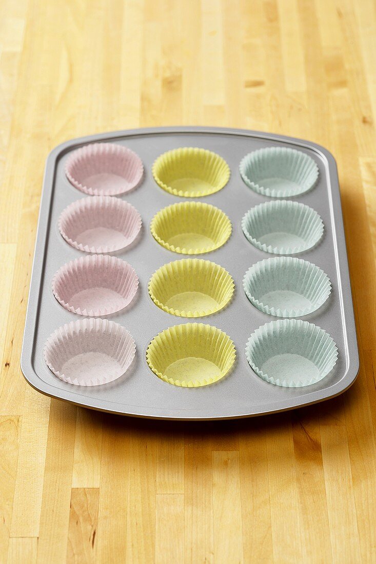 Muffin Pan Lined with White, Yellow and Blue Paper Muffin Cups