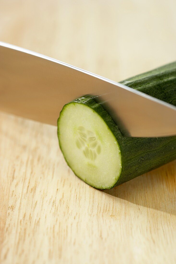 Knife Slicing a European Seedless Cucumber