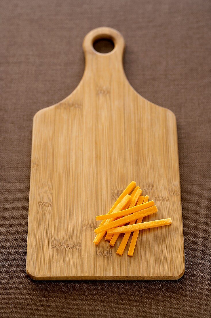 Cutting Board with a Pile of Carrot Sticks