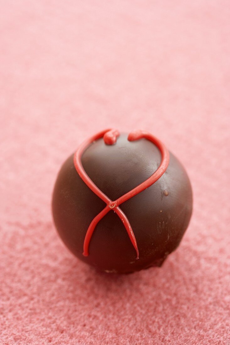 A Single Chocolate Truffle with Red Frosting Heart