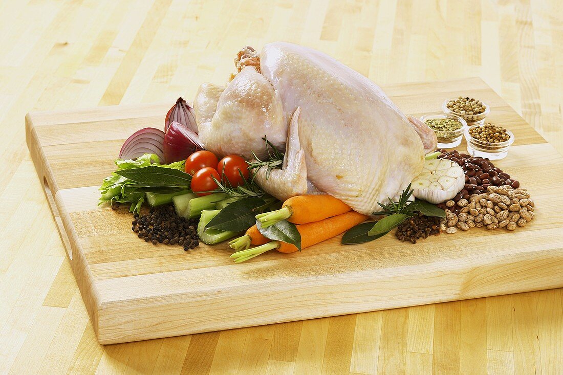 Whole Chicken on a Cutting Board with Spices and Vegetables