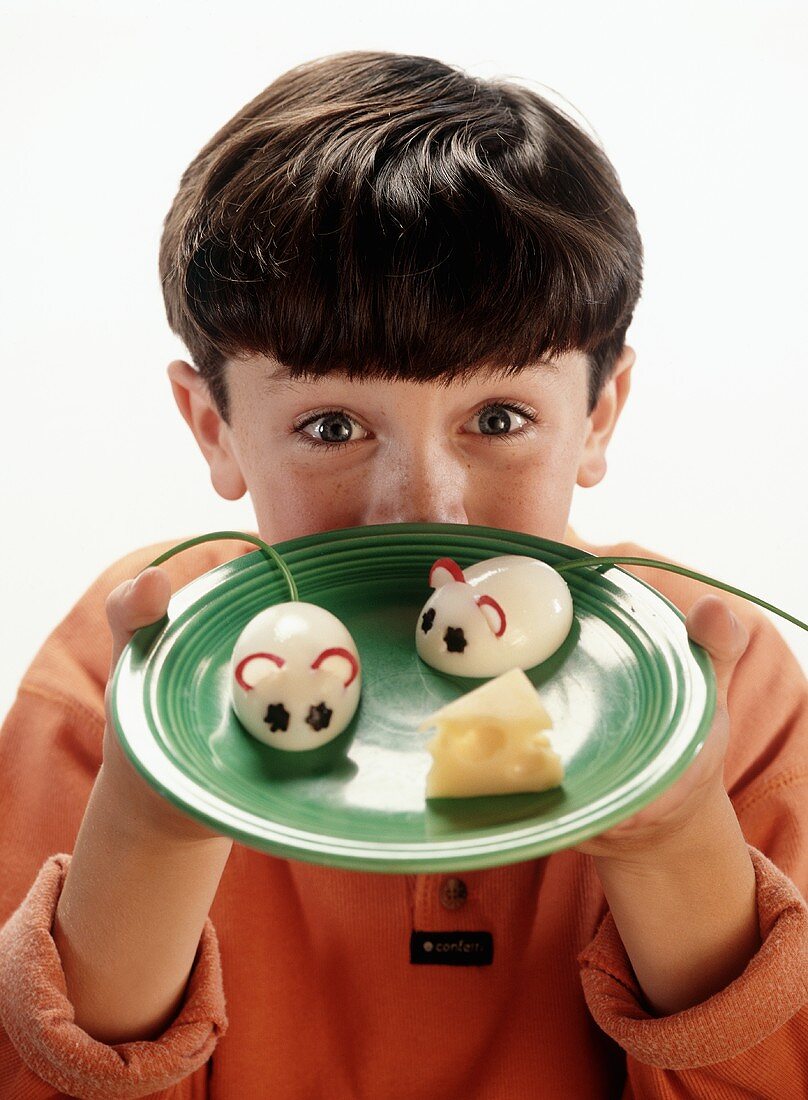 Boy Holding a Plate with Two Boiled Egg Mice and a Wedge of Swiss Cheese