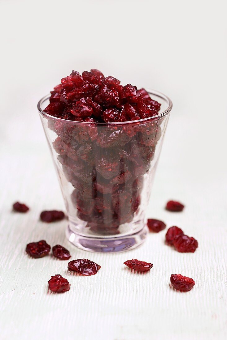 Getrocknete Cranberries in und neben Glas