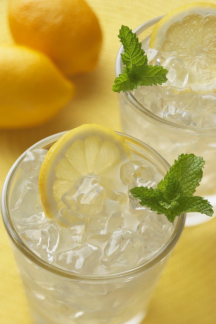 Lemonade Over Ice in Two Tumbler Glasses with Lemon Slices and Mint, Lemons