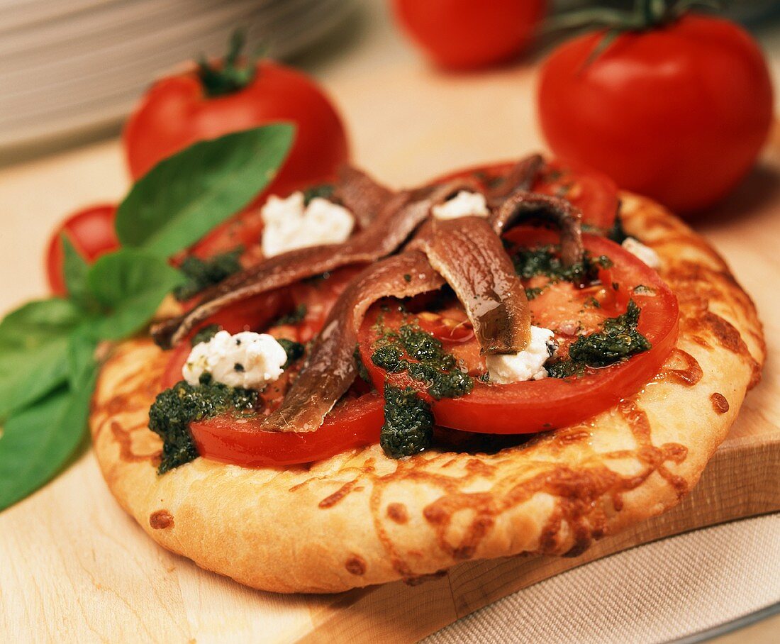 Minipizza mit Tomaten, Pesto, Ziegenkäse & Anchovies