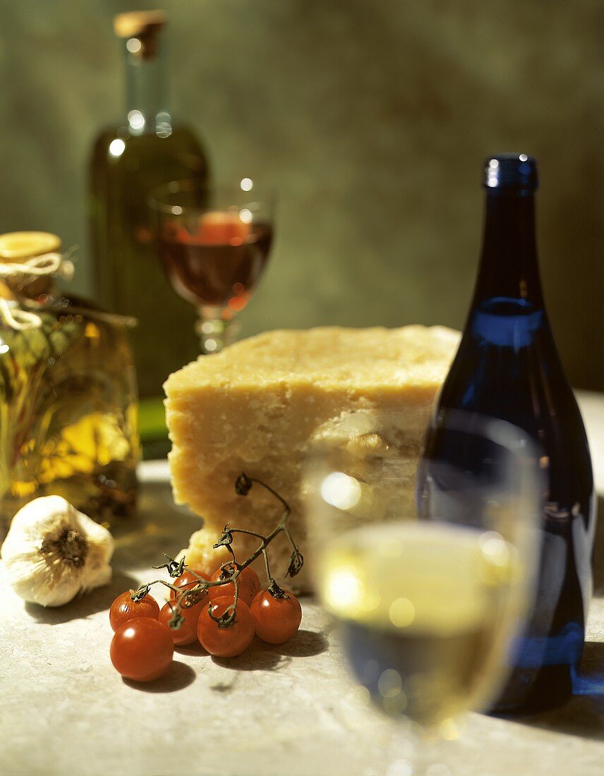 Stillleben mit Parmesan, Tomaten, Öl, Knoblauch und Wein