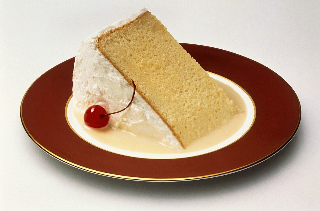 Stück Torte (Rührkuchen mit Eiweissglasur) auf Vanillesauce