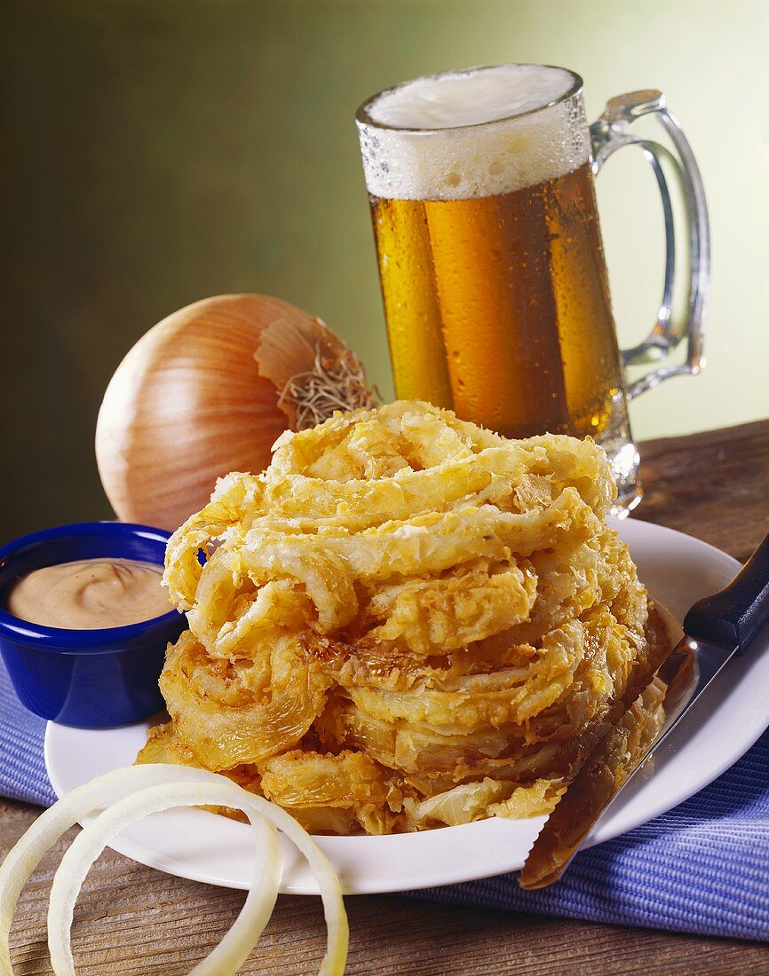 Frittierte Zwiebelringe mit Dip und Bier