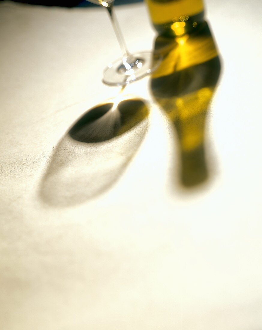 Schatten einer Weissweinflasche & eines Weinglases