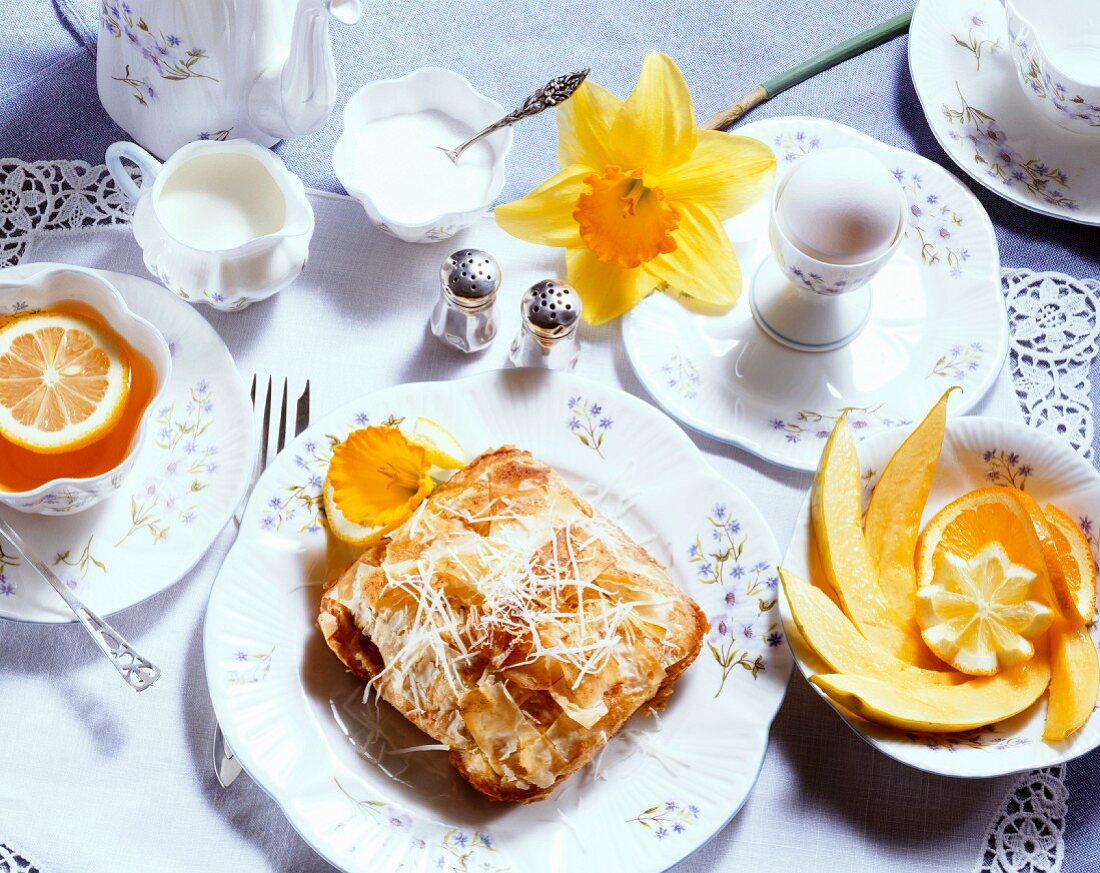 Frühstück mit Gebäck, gekochtem Ei und Zitronentee
