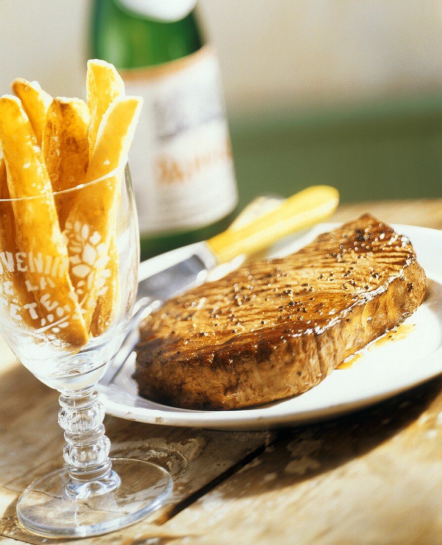 Gebratenes Steak mit Pommes frites in einem Glas