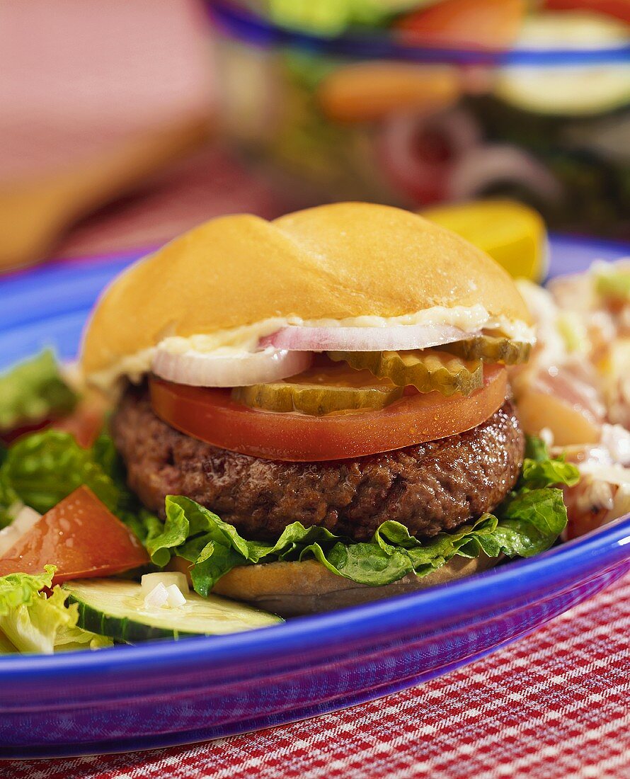 Hamburger mit Mayonnaise, Zwiebeln, Essiggurken und Tomate