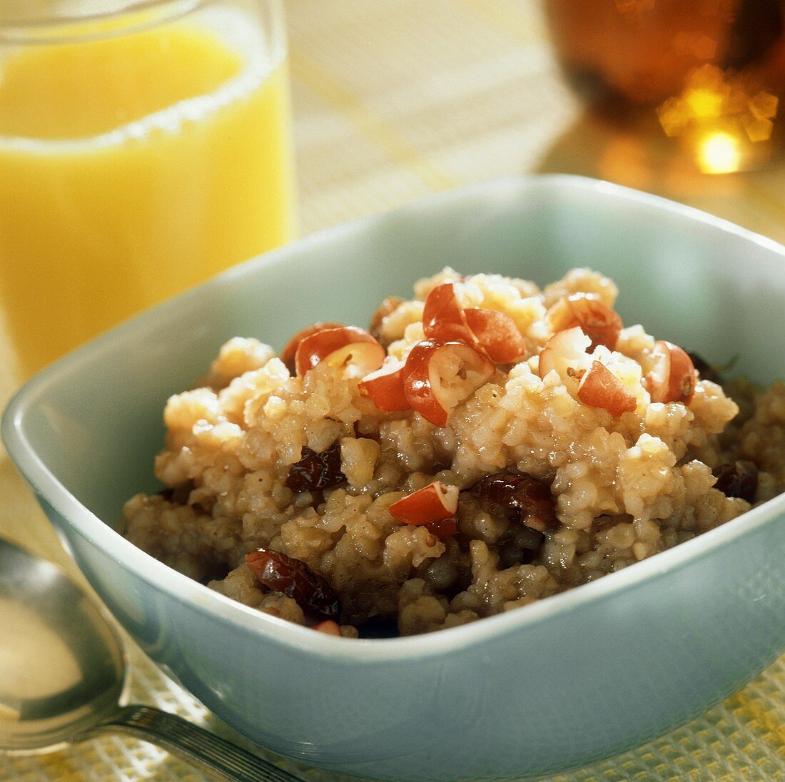 Porridge mit Rosinen und roten Trauben; Orangensaft