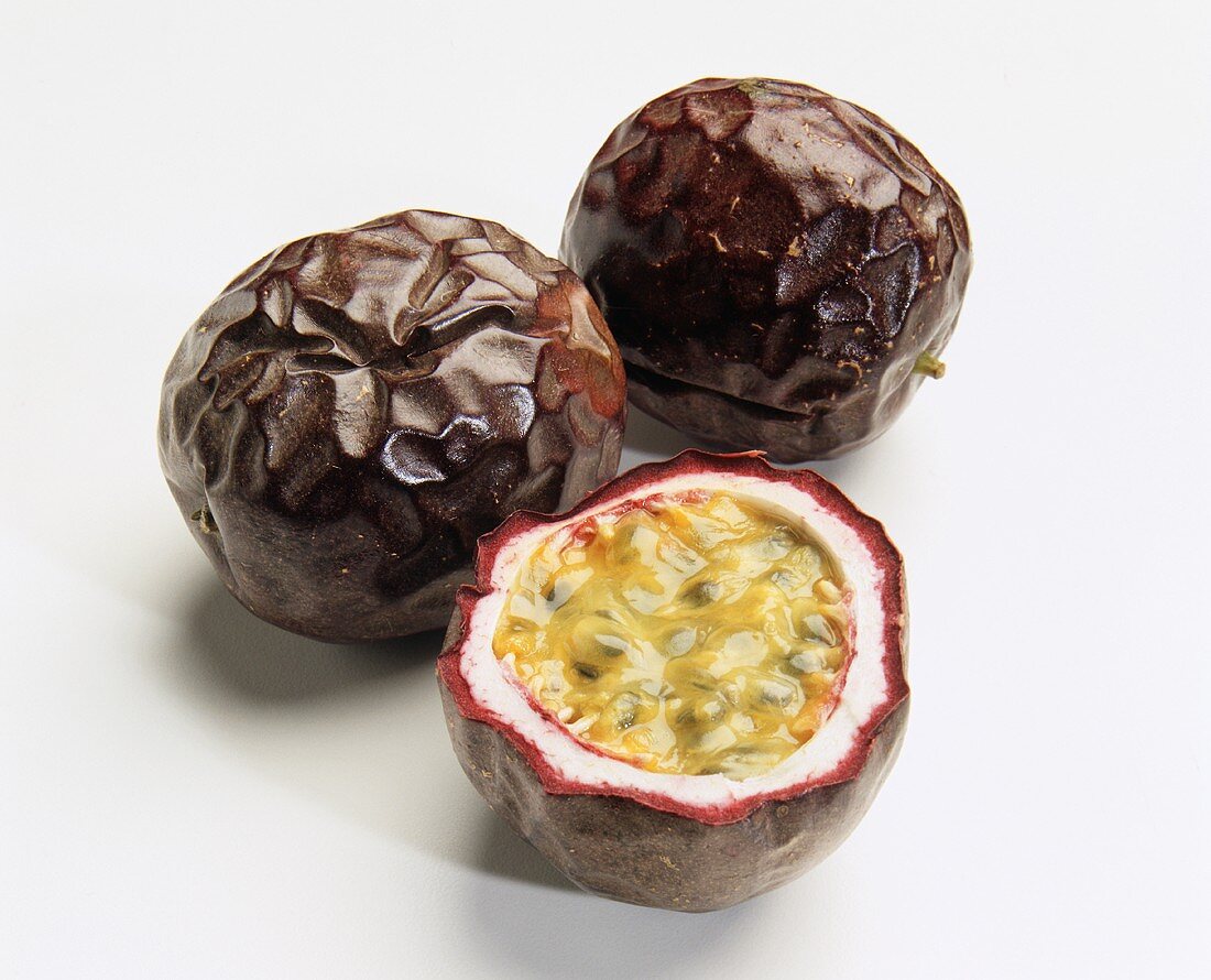 Zwei ganze und eine halbe Maracuja (Purpurgranadilla)