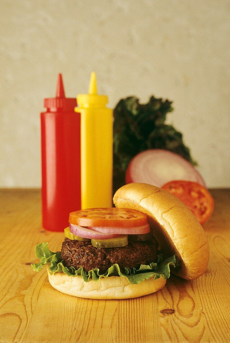 Hamburger on Table with Ketchup and Mustard Bottles