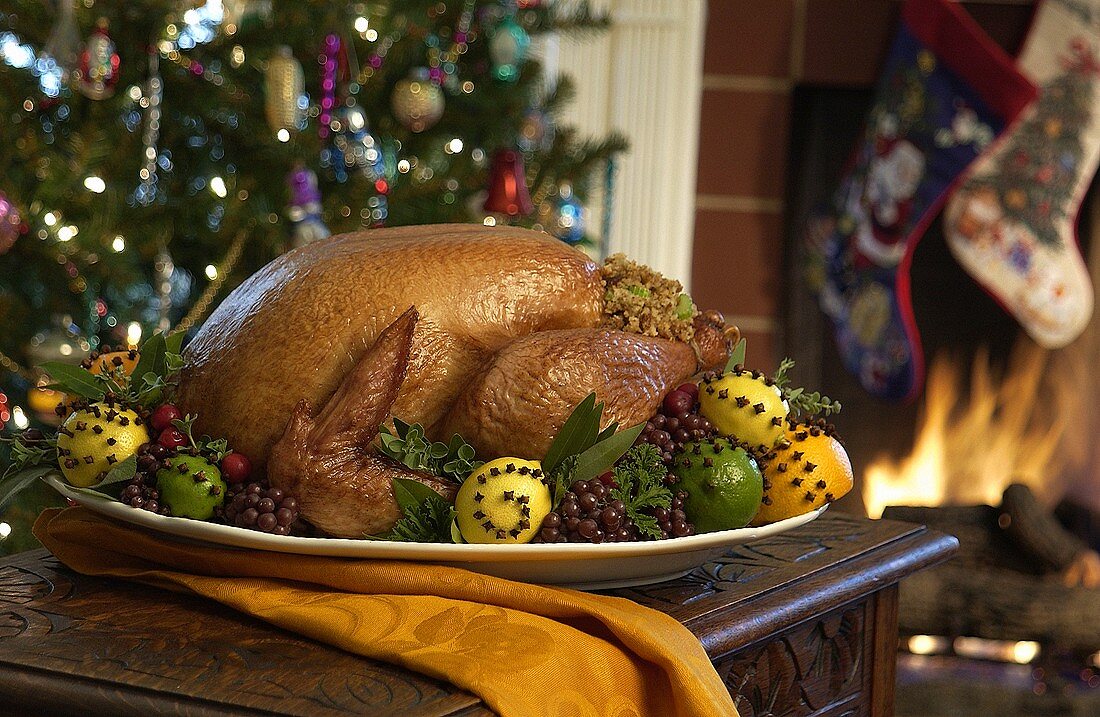 Truthahnbraten auf dem Tisch vor Weihnachtsbaum und Kamin