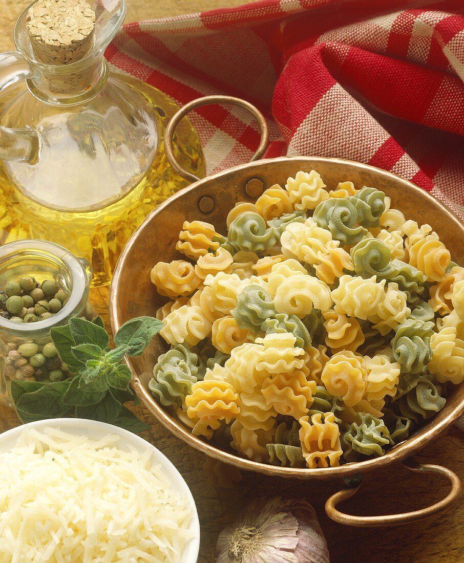 Zutaten für Pasta: Bunte Radiatori, geriebener Käse und Öl