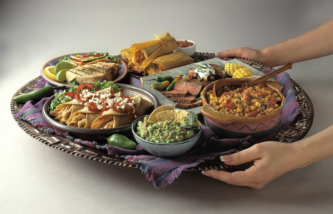 Hände servieren mexikanische Gerichte auf Tablett
