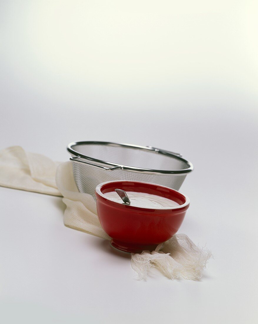 Bowl of Yogurt with a Strainer and Cheese Cloth