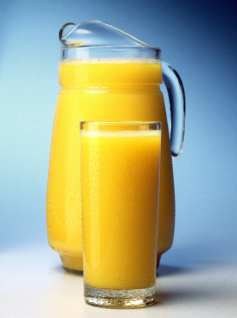 Orangensaft im Glas und Glaskrug