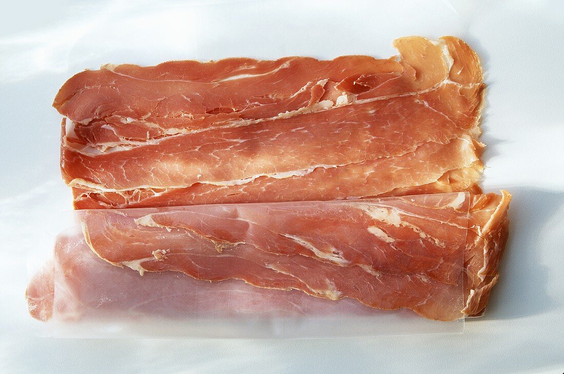 Prosciutto in Scheiben auf Papier