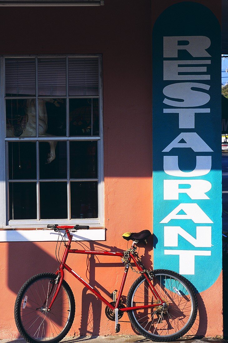 Fahrrad lehnt an Wand eines Restaurants