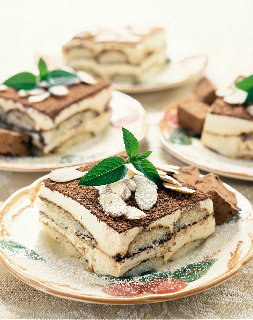 Tiramisu mit Mandelblättchen auf mehreren Tellern