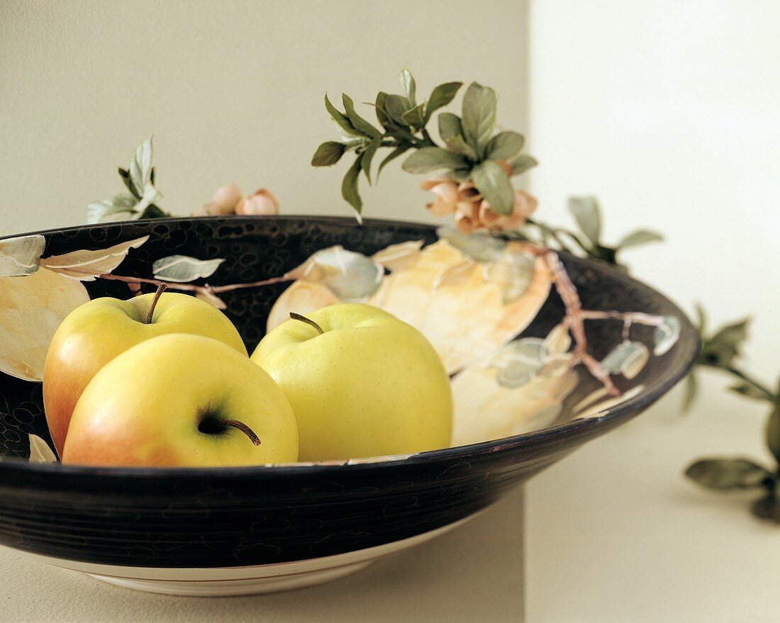 Golden Delicious Äpfel in einer Schale; Apfelblüten