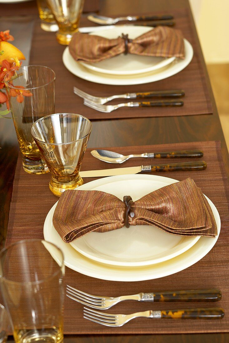 Gedecke mit braunen Servietten am herbstlich gedeckten Tisch