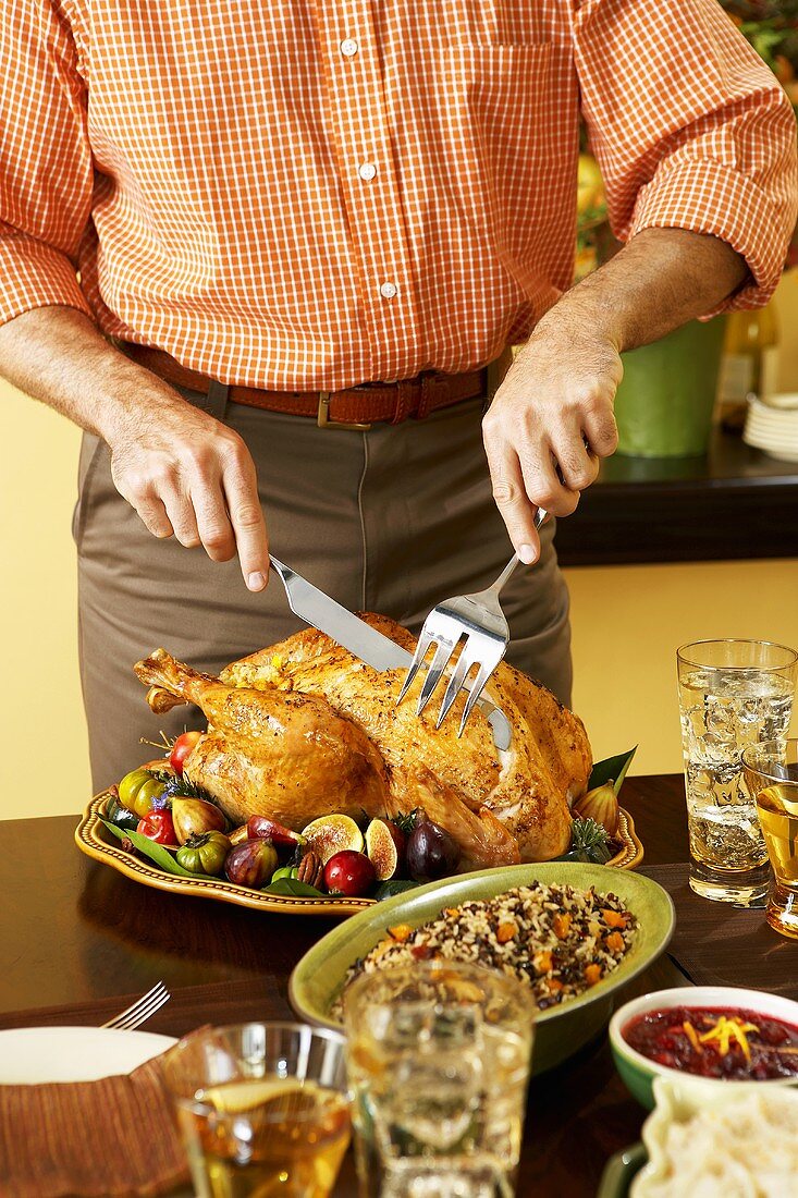 Mann tranchiert gebratenen Turkey zu Thanksgiving
