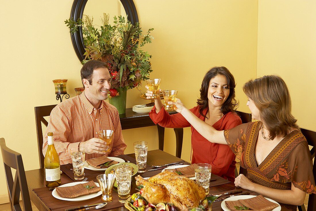 Frauen stossen mit Weingläsern an beim Thanksgiving-Essen