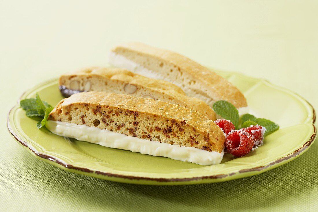 Biscotti mit Schokoladenglasur und Himbeeren auf Teller