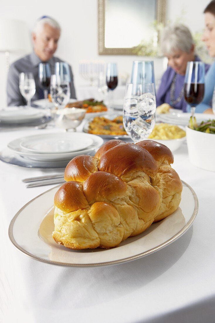 Challah Bread on Hanukkah Table, People Sitting at Table