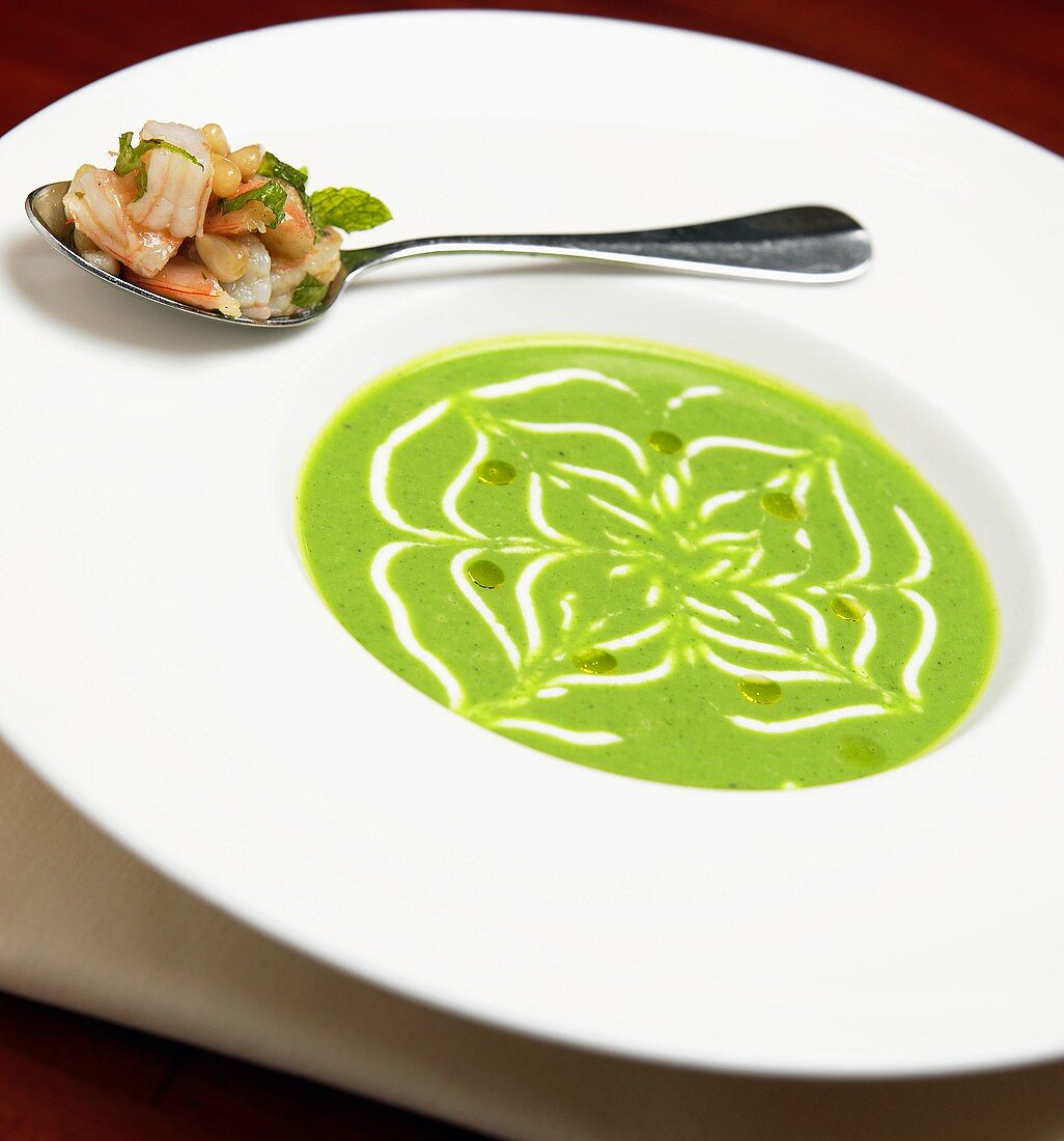 Erbsensuppe mit einem Löffel Garnelen